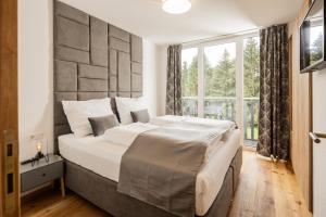 sypialnia z dużym łóżkiem i dużym oknem w obiekcie Granit Appartements w mieście Mauterndorf