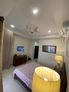 1 dormitorio con 1 cama y TV. en The River View Apartment, en Rawalpindi