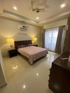 a bedroom with a bed and two lamps and a window at The River View Apartment in Rawalpindi