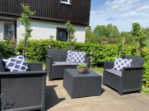 a group of wicker chairs with blue and white pillows at Haus Talruhe in Kurort Altenberg