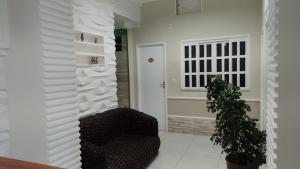 uma sala de estar com uma cadeira e uma porta em Hipolitus Apart Hotel em Lagarto