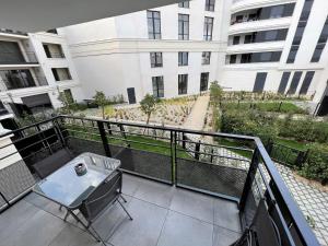 d'un balcon avec une table et une vue sur un bâtiment. dans l'établissement Appartement 6 pers Val d'Europe - Disneyland Paris - Captain America, à Chessy