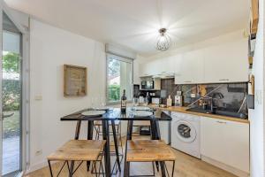 a kitchen with a table with chairs and a counter top at To Be Discovered L'escapade Cosy in Pradines