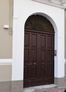 een grote houten deur in een wit gebouw bij La Casetta di Vale in Taranto