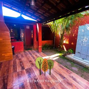 una camera con pavimento in legno e palma di Recanto Taquari - Praia e cachoeira a Parati