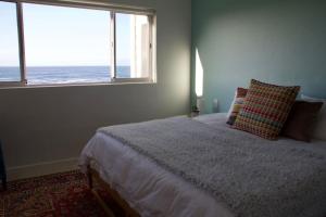 a bedroom with a bed with a view of the ocean at Seafront house with a view in Kleinmond