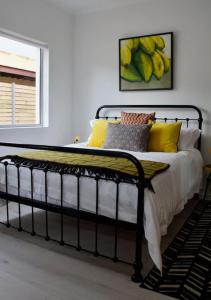a bed with yellow pillows and a painting on the wall at Seafront house with a view in Kleinmond