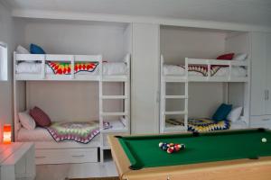 a room with a pool table and bunk beds at Seafront house with a view in Kleinmond