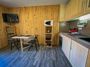 een keuken met een tafel en een aanrecht bij Studio balcon vue Alpes pistes de ski à 5 min in Saint-Étienne-de-Tinée