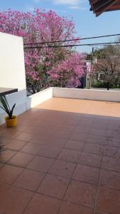a patio with a bench and some pink flowers at Duplex Donovan in Resistencia
