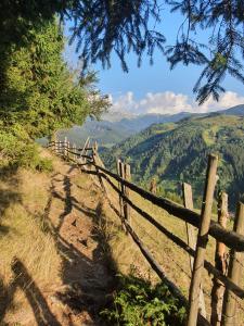 una valla de madera en una colina con montañas en el fondo en ALEGRIA - MOIECIU DE SUS, en Moieciu de Sus