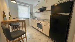 eine Küche mit einem schwarzen Kühlschrank und einem Tisch in der Unterkunft Apartment Strauss #EINS 1,5 Zi BS-östliches Ringgebiet in Braunschweig