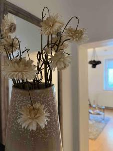 eine Vase voller weißer Blumen auf dem Tisch in der Unterkunft Apartment Strauss #EINS 1,5 Zi BS-östliches Ringgebiet in Braunschweig