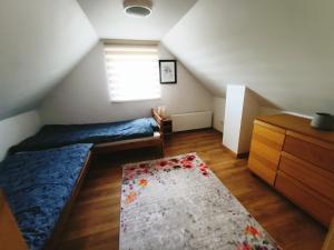 a attic bedroom with a bed and a rug at Siedlisko Dwa Żurawie - Uroczy domek nad stawem, z kominkiem, obok konie in Czarna Huta +20 photos