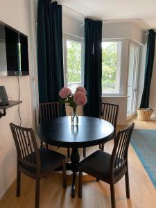 a dining room table with chairs and a vase with flowers at Beautiful apartment with balcony in Berlin