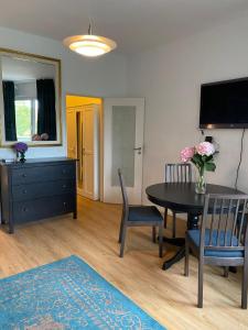 uma sala de estar com uma mesa e cadeiras e uma televisão em Beautiful apartment with balcony em Berlim