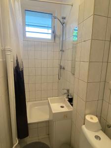uma casa de banho com um lavatório, um WC e uma janela. em Beautiful apartment with balcony em Berlim