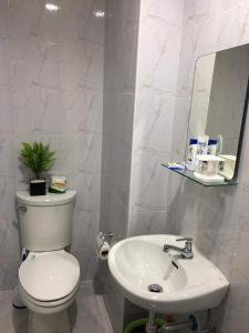 y baño con aseo blanco y lavamanos. en Delta Charlie Staycation CDO, en Cagayan de Oro