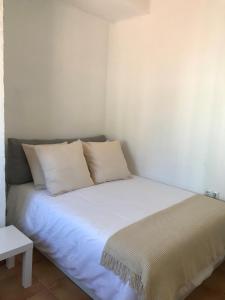 a bed with white sheets and pillows in a room at Los Remedios- Calle Niebla in Seville