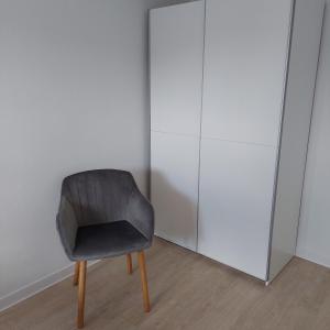 una silla gris sentada en una habitación junto a un armario en Apartament26 en Stronie Śląskie