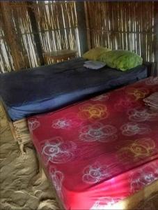 Cama en habitación de madera con manta roja en Arridub Island-Iguana, en Playón Chico