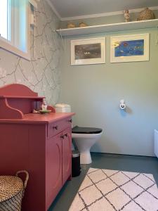 a bathroom with a pink cabinet and a toilet at Unique and charming holiday home with fantastic sea views in Tromsø
