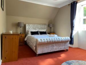 een slaapkamer met een bed, een tafel en een raam bij Fabulous 2 Bedroom House just outside Edinburgh in Auchendinny