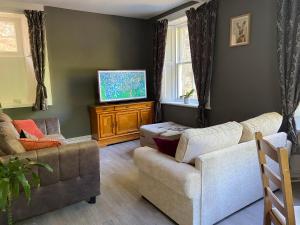 a living room with two couches and a flat screen tv at Fabulous 2 Bedroom House just outside Edinburgh in Auchendinny