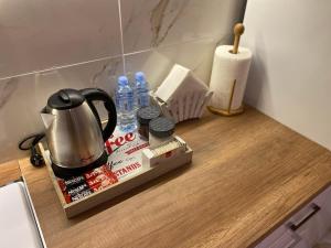 a counter top with a tea kettle and bottles of water at Old Bazaar Apartment with Private Parking in Skopje