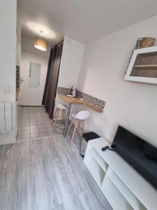 a living room with a couch and a table at Petit Appartement Cosy in Chaville +2 photos