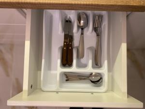 a white drawer with utensils in it at Old Bazaar Apartment with Private Parking in Skopje