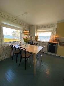 a kitchen with a wooden table with chairs and a table and a table at Unique and charming holiday home with fantastic sea views in Tromsø