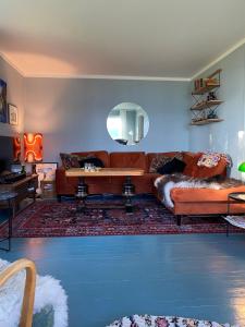 a living room with a couch and a mirror at Unique and charming holiday home with fantastic sea views in Tromsø