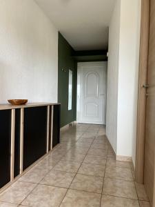 a hallway with a white door and a tile floor at Superbe appartement en résidence avec piscine proche plage in Linguizzetta