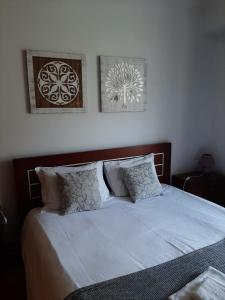 a bedroom with a bed with two pictures on the wall at Luis Place Machico LifeStyle in Machico