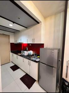 a kitchen with a sink and a refrigerator at Yhanz Z Sea Residences in Manila