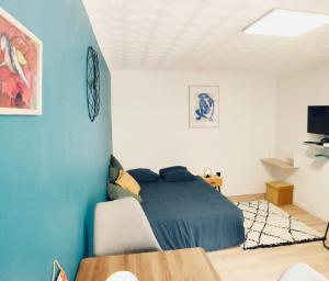 - une chambre avec un lit et un mur bleu dans l'établissement Studio - WIFI - Train Station - Love Bridgi home, à Forbach