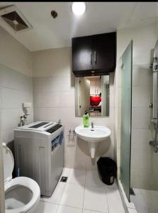 a bathroom with a toilet and a sink at Yhanz Z Sea Residences in Manila