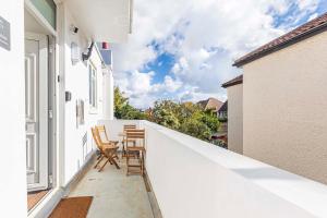 a balcony with two chairs and a table on it at The White House - Lux Southbourne beach 3 bed stay in Southbourne