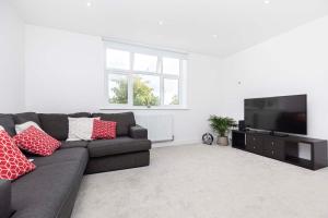 sala de estar con sofá y TV de pantalla plana en The White House - Lux Southbourne beach 3 bed stay, en Southbourne