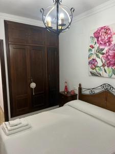 1 dormitorio con cama y lámpara de araña en Alojamiento las Delicias, en Hornachuelos