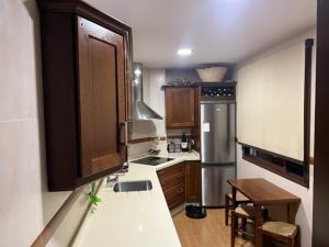 a kitchen with a sink and a refrigerator at Alojamiento las Delicias in Hornachuelos