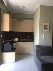 a kitchen with wooden cabinets and a bed in a room at Apartment GM in Neoi Epivates