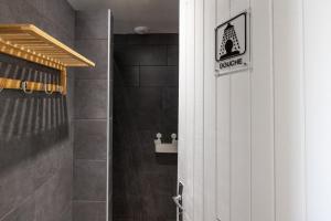 baño con ducha y puerta con letrero de disculpa en TENTE SAFARI Lodge FERME CARRIQUE, en Tardets-Sorholus