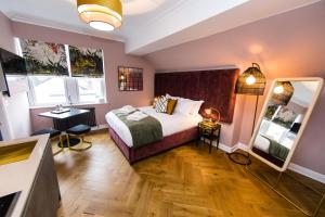 a hotel room with a bed and a mirror at Dragon Villas by Maison Parfaite - Luxury Studios & Apartments - Harrogate in Harrogate