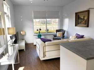 a living room with a white couch and a window at Het Appense veld in Klarenbeek