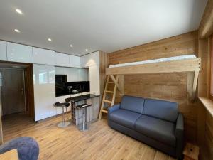 a living room with a blue couch and a kitchen at Rendez-vous au studio in Valloire