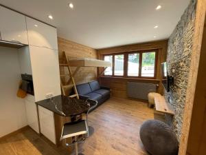 a living room with a blue couch and a stone wall at Rendez-vous au studio in Valloire
