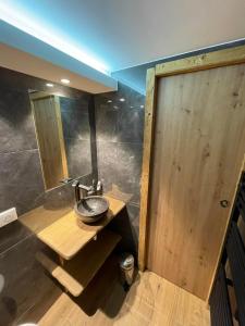 a bathroom with a wooden sink and a wooden door at Rendez-vous au studio in Valloire +1 photo