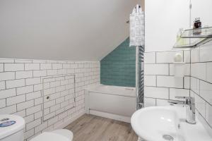 a white bathroom with a toilet and a sink at Carlile House - London 5 bedroom Free Parking & Garden by Damask Homes in London